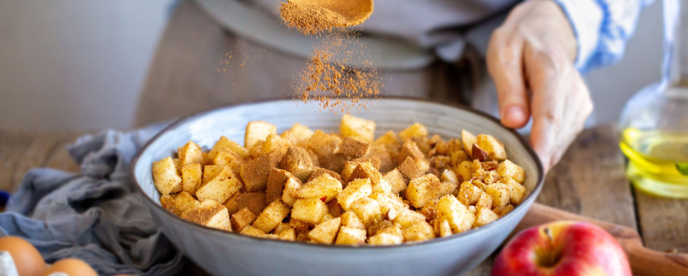 Chopped up apples being coated in cinnamon for the apple crisp.