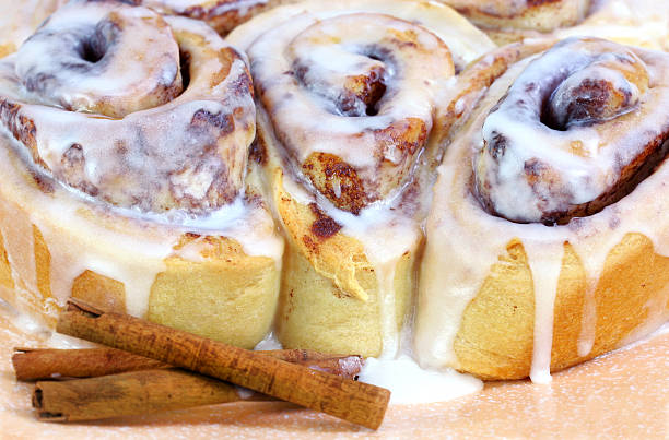 three fresh baked cinnamon buns - eggnog cinnamon rolls stock pictures, royalty-free photos & images