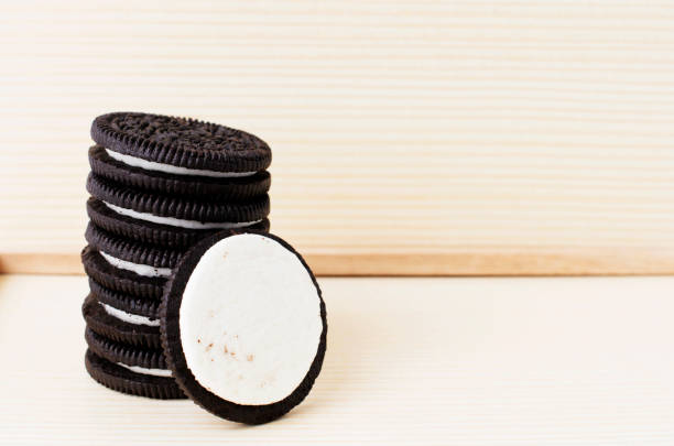 close-up of sandwich cookie stack on table against wooden tray - oreos stock pictures, royalty-free photos & images