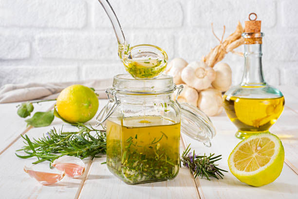 fresh homemade salad dressing with rosemary, lemon and garlic - lemon vinaigrette stock pictures, royalty-free photos & images