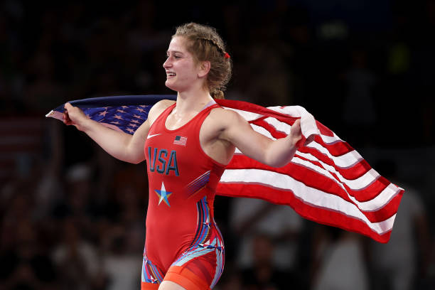 Amit Elor of Team United States celebrates with the United States flag following victory against Meerim Zhumanazarova of Team Kyrgyzstan during the...