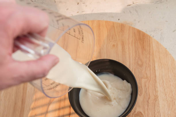 pouring milk - pouring buttermilk into bowl stock pictures, royalty-free photos & images