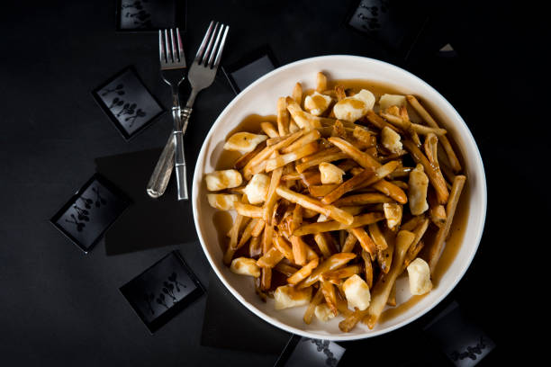 overhead view of poutine in bowl with forks on table - poutine stock pictures, royalty-free photos & images