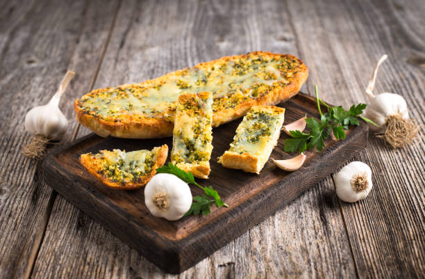 fresh garlic bread with cheese and spices on the wooden table - garlic bread stock pictures, royalty-free photos & images