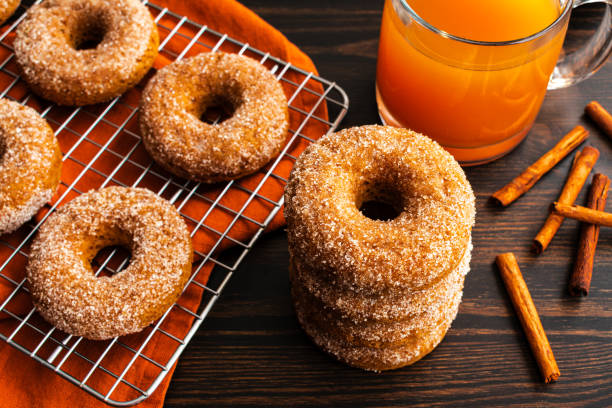 baked apple cider donuts with cinnamon sugar coating - baked cinnamon apple cider donuts stock pictures, royalty-free photos & images