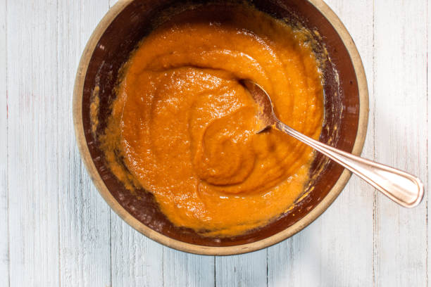 top view of mixing bowl of pumpkin batter - pumpkin pie batter stock pictures, royalty-free photos & images