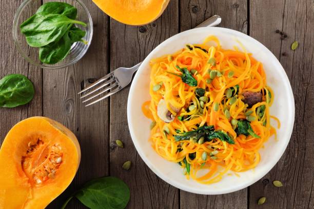 healthy butternut squash spirilized noodle dish, above scene on wood - squash noodles stock pictures, royalty-free photos & images