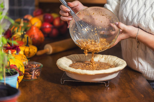 woman preparing homemade pecan pie for the holidays - baking pecan pie stock pictures, royalty-free photos & images