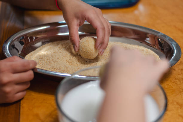 friends bonding and preparing food at home - making arancini balls stock pictures, royalty-free photos & images