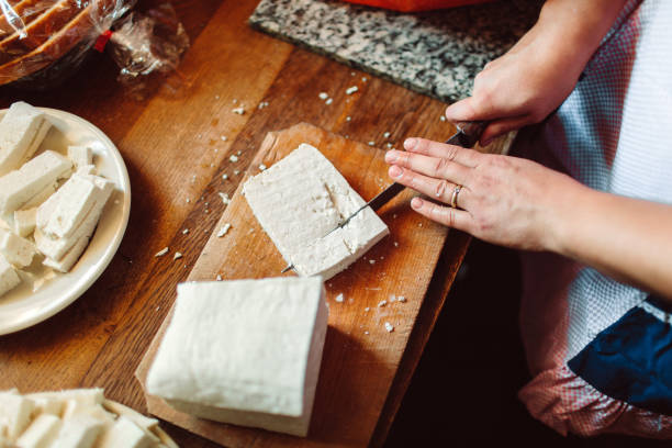 closeup shot of female hands cutting a block of white cheese - cutting feta block stock pictures, royalty-free photos & images