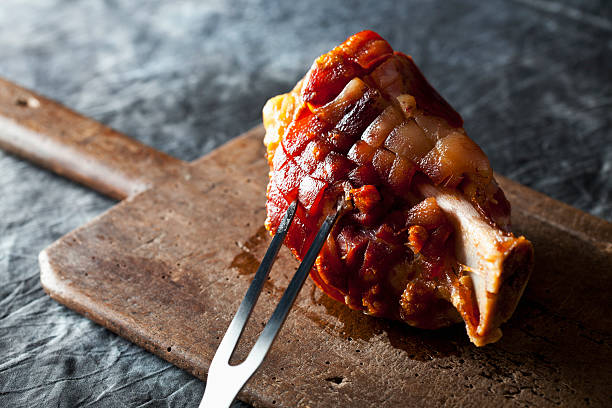 grilled knuckle of pork with fork on chopping board, close up - ham hocks stock pictures, royalty-free photos & images