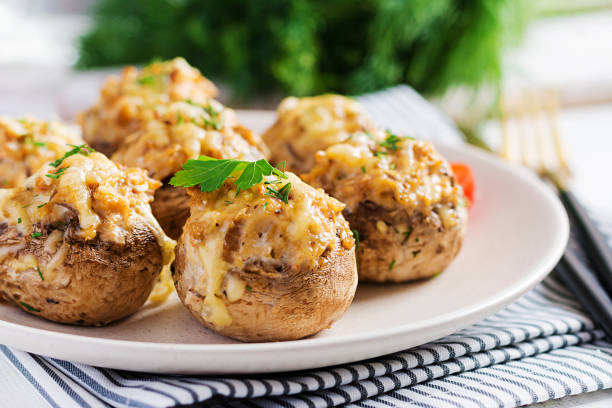 baked mushrooms stuffed with chicken minced meat, cheese and herbs on light plate. - stuffing mushrooms stock pictures, royalty-free photos & images