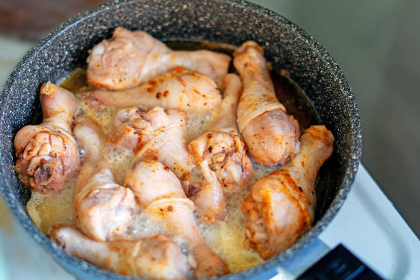 sizzling chicken legs browning in a skillet - browning chicken stock pictures, royalty-free photos & images