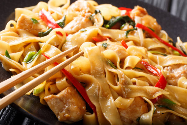 drunken noodles pad kee mao with chicken, basil, chili pepper and sauce close-up on a plate. horizontal - drunken noodles stock pictures, royalty-free photos & images