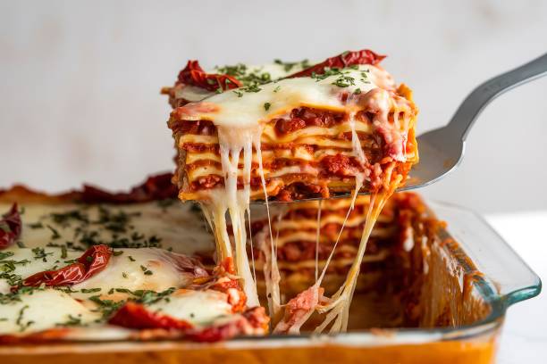 a delectable dish of lasagna served in a baking dish - making homemade lasagna stock pictures, royalty-free photos & images