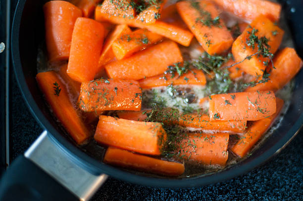 honey-glazed carrots - making glazed carrots stock pictures, royalty-free photos & images