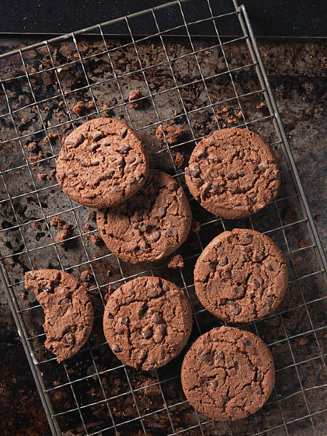 overhead view of double chocolate chip crunchy cookies on cooling rack - devils food cookies stock pictures, royalty-free photos & images